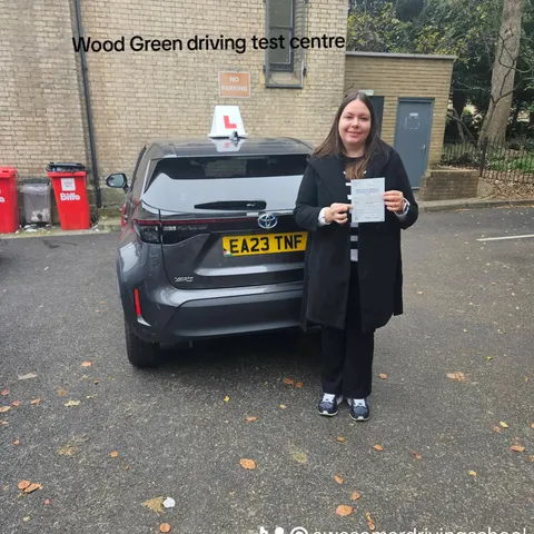 Pupil holding a pass certificate at Wood Green driving test centre