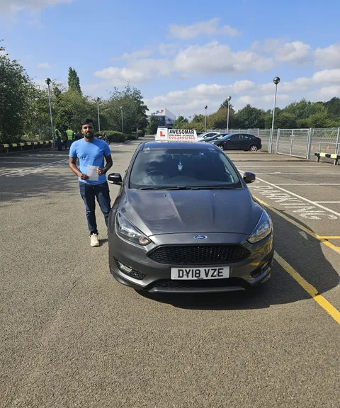 Pupil holding a driving test pass certificate
